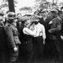 Öffentliche Erniedrigung von zwei Juden in Polen. Deutsche Soldaten und polnische Zivilisten sehen zu, während ein Jude in Tomaszów Mazowiecki gezwungen wird, einem anderen Juden den Bart abzuschneiden. Fotograf: USHMM